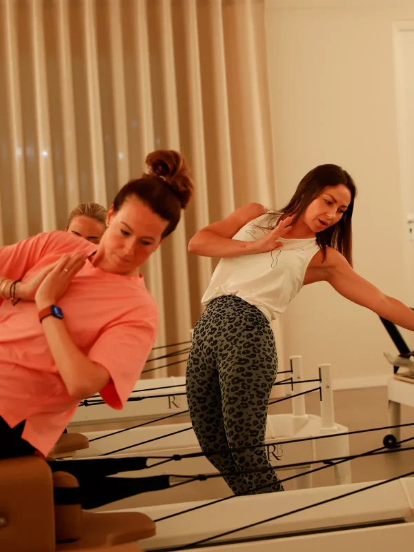 Instructeur en deelnemers tijdens een Reformer Pilates-les bij SolidPilates